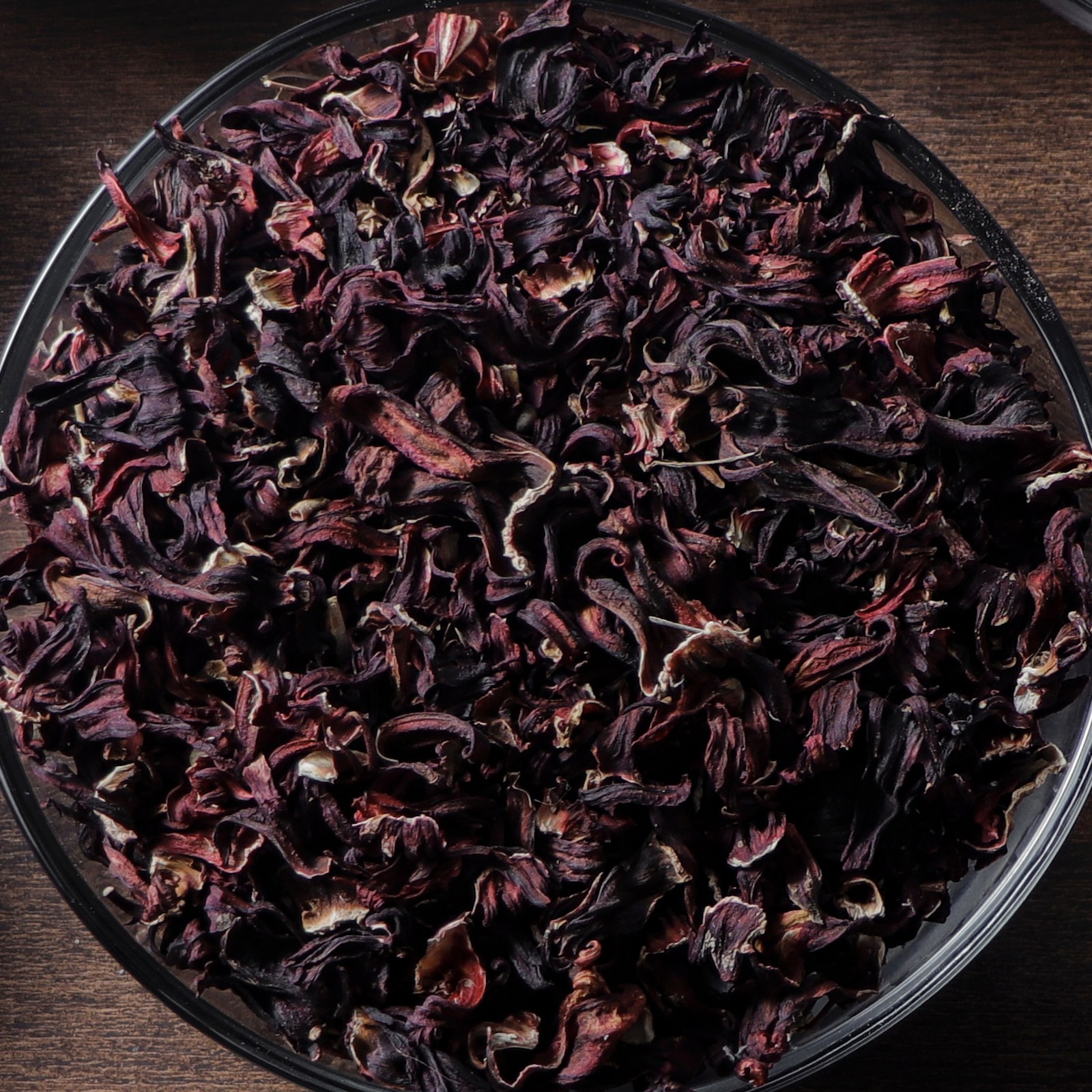 Dried hibiscus calyces heaped in a glass bowl