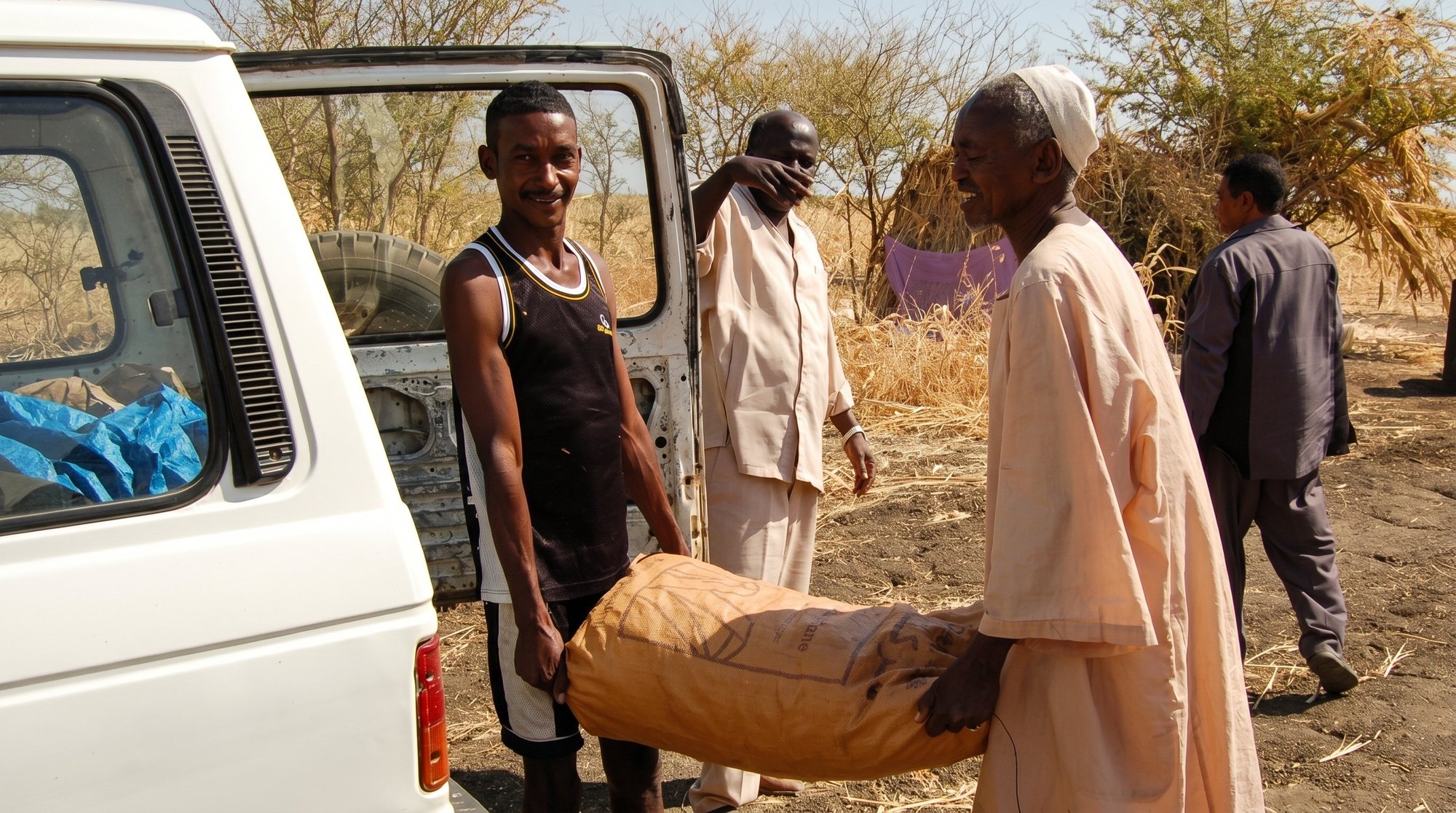Harvesters loading bagged gum for transport from a gum-belt village